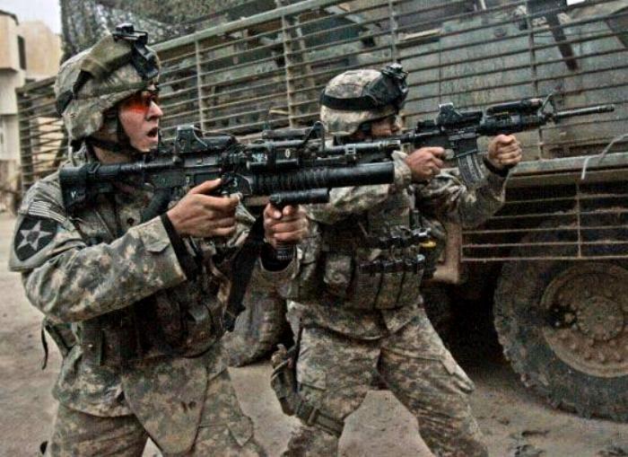 The grenadier is engaging the enemy with his M203 40mm Grenade Launcher supported by the M203 forward handgrip called the M203grip.